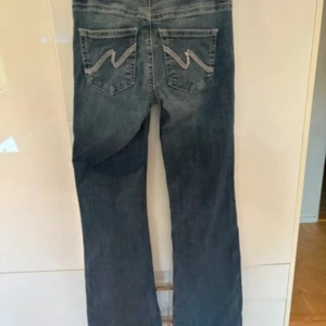 Bootcut jeans med låg midja från Nelly - Bootcut jeans från Nelly i klassisk blå tvätt med snygga kontrastsömmar på bakfickorna. Modellen har låg midja och raka ben med lätt utsvängning. Jeansen är tillverkade i jeansmaterial och har knapp- och dragkedjestängning framtill.