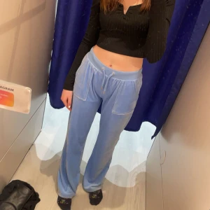 Ljusblå juicy byxor med fickor bak - Säljer ett par ljusblå juicy byxor med bred resår i midjan och snörning framtill. Byxorna har stora fickor både fram och bak, samt raka ben med loose passform. Materialet är mjukt och skönt, perfekt för chill dagar. Byxorna har blekt midja därav billigt pris men annars bra