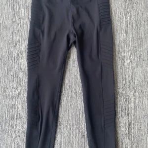 Svarta leggings från Spyder Active - Säljer ett par svarta leggings från Spyder Active i storlek L. De har coola ribbade detaljer längs benen och en snygg logga med spindel på baksidan. Materialet är stretchigt och passar perfekt för träning eller chill. Grym passform och stilren look. Mått Midjan: ca 37 cm Längd från grenen och ner: ca 64  77% polyester och 23% elastan  Kommer från ett djur och rökfritt hem.