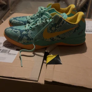 Nike Kobe green glow  US11 UE45 - Säljer ett par Nike Kobe sneakers i grön och gul färg med coolt ormmönster. Skorna har snörning, platt sula och är tillverkade i syntetmaterial. Perfekta för dig som kör basket men vill också sticka ut framför alla. Dom köpte min mamma från USa för några år sedan, men de har varit i min garderob och har aldrig använt dom bara testade en gång och de va för stora för mig. Boxen finns inte pga hon hade ej plats i resväskan. Passar till 44 storlek 
