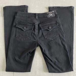 Svarta bootcut jeans True Religion - Säljer dessa true religion jeans i bra skick förutom små slitningar längst ner på jeansen. Kontakta för fler bilder eller frågor, pris kan diskuteras!