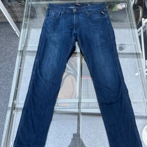 👖 Replay jeans herr – M914 Slim Fit W31 L32 - Snygga Replay jeans i mörkblå denim, modell M914 Slim Fit. Smal men bekväm passform med lagom stretch. Tillverkade i Tunisien av 98% bomull och 2% elastan. Storlek W31 L32 (motsvarar medium/slim fit). I mycket fint skick, sparsamt använda. Passar både vardag och fest. Klassiska och stilrena premiumjeans med italiensk design.