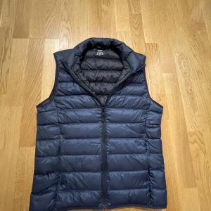 Mörkblå uniqlo dun väst  - Säljer nu en mörkblå uniqlo väst för den blivit liten. Stilren och väldigt snygg. Storleken är xs men den är lite liten i stolrlek. Skirv vid funderingar och pris kan diskuteras.