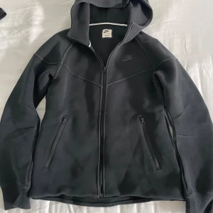 Svart Dam Nike Tech - En svart Nike Tech hoodie för kvinnor. Storlek Xs men passar större storlekar som S och M. Aldrig använt.
