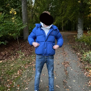 Blå pufferjacka från Polo Ralph Lauren - Säljer en blå pufferjacka från Polo Ralph Lauren med huva och dragkedja framtill. Jackan har två stora fickor och en liten röd logga på bröstet. Perfekt för kyliga dagar och har en schysst, lite oversized passform.