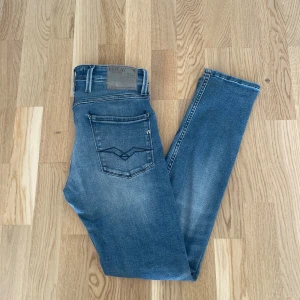 Ljusblå Replay Anbass jeans W30 L32 - Jag säljer dom här snygga Replay Anbass jeansen som är i storlek W30 L32. De är använda men fortfarande i fint skick utan skador. Tveka inte att höra av er!                                                           Mått: Längd 103cm. Midja 39cm