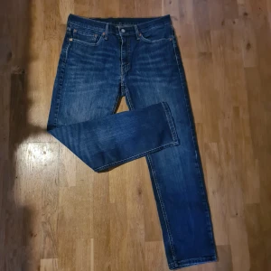 Levi's 541 blå jeans straight fit - Säljer ett par klassiska Levi's 541 jeans i blå denim. Jeansen har fem fickor, raka ben och normal passform. Snygg tvätt med lätt slitning och ikonisk läderpatch bak i midjan.