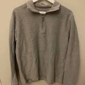 Grå half zip tröja från Topman - Snygg grå långärmad tröja från Topman med half zip-dragkedja i halsen. Tröjan har en klassisk passform och är tillverkad i mjuk bomull, perfekt för lager-på-lager under höst och vinter.