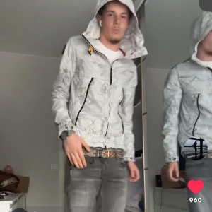 Parajumpers Mountain Wireframe vindjacka - Säljer en Parajumpers Mountain Wireframe vindjacka i ljusgrått med unikt geometriskt mönster. Jackan har huva, svarta dragkedjor och cool patch på ärmen. Perfekt för dig som gillar streetwear och vill sticka ut med en snygg och funktionell jacka. Säljs inte längre, helt nytt skick. Mycket eftertraktad. Nypris 7tkr 