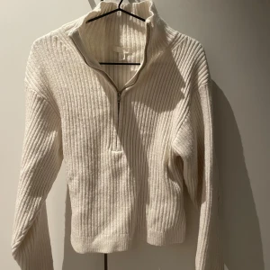 Vit ribbad stickad half zip tröja - Säljer en vit ribbad stickad tröja från H&M med half zip.