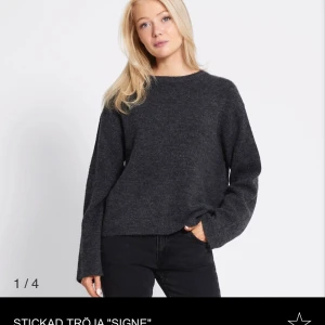 Mörkgrå stickad tröja Signe - Mysig mörkgrå stickad tröja med rund hals och långa ärmar. Tröjan har en loose passform och är perfekt för lager-på-lager. Enkel design utan detaljer, vilket gör den lätt att matcha med olika stilar. Slutsåld på lager så köp! 