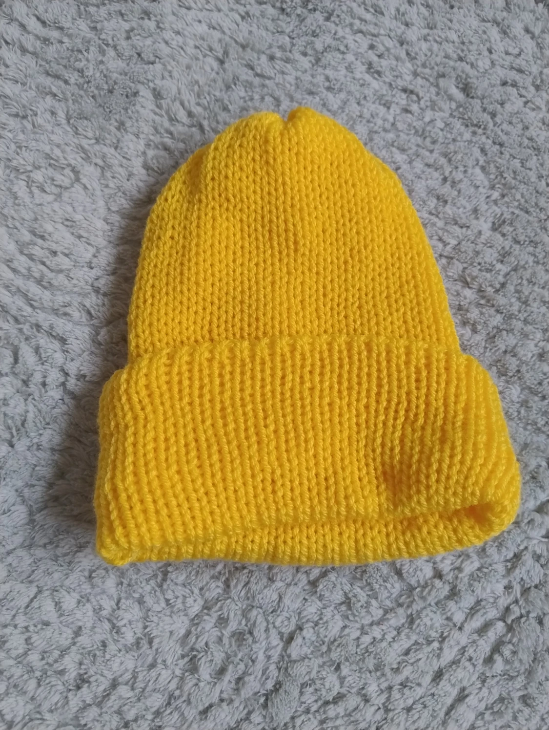 Gul stickad mössa med uppvikt kant
