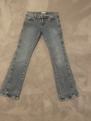 Perfekt jeans i ljusblå bootcut, strl 36 - Snygga ljusblå jeans från Perfect Jeans i storlek 36. Modellen har klassisk bootcut och raka ben, med fem fickor och coola detaljer på bakfickorna. Jeansen är tillverkade i jeansmaterial och har normal passform.