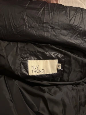 Svart pufferjacka med hög krage - Säljer en svart pufferjacka med hög krage och dragkedja framtill. Jackan har en boxig passform och är vadderad för extra värme. Perfekt för kalla dagar och har en stilren look som funkar till det mesta. Långärmad och med diskreta fickor på sidorna.ganska kort vilket är najs men har för många jackor därav att jag säljer och vill bara bli av med kläderna jag säljer därav priset ! Använt 1 gång 