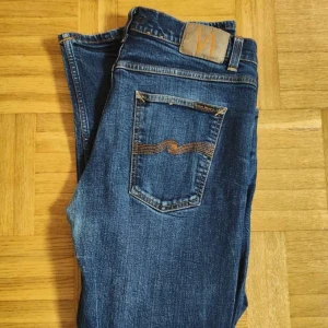 Nudie Jeans - Nudie Jeans för män. Jeansen är i väldigt fint skick men har tyvärr en väldigt liten skada som inte syns vid användning. Modellen är Steady Eddie. Storlek Waist 36 / Lenght 32. PRIS KAN DISKUTERAS!