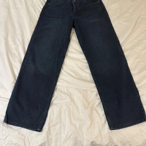 Wide jeans från Weekday mörkblå - Säljer ett par mörkblå jeans från Weekday i modellen wide. Klassisk femficksdesign med raka, breda ben och normal passform. Jeansen är tillverkade i bomull och har en snygg, enkel look som funkar till många stilar.