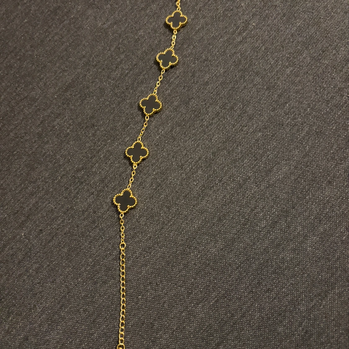 Guldigt halsband med svarta klöver