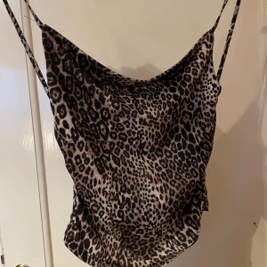 Leopardmönstrad linnetopp från Stradivarius  - Säljer en snygg leopardmönstrad linnetopp från Stradivarius med tunna axelband. Toppen har en avslappnad passform och coolt fall framtill. Den är i nyskick och säljs i befintligt skick. 