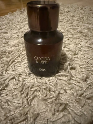 ZARA Cocoa & Latte parfym - Snygg och trendig parfym från ZARA med namnet Cocoa & Latte. Perfekt för dig som vill sticka ut med en modern look. Flaskan har en stilren design som passar in i alla miljöer. Lukten är rökig men samtidigt söt! 100 ml