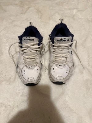 Nike Air Monarch vita sneakers - Hej,nu säljer jag mina Nike skor.Dem är inte i bästa kvalité, men tar dig från A till B. Anledningen till att jag säljer dem är för att jag inte har någon användning till dem längre. (Skriv för mer frågor). 