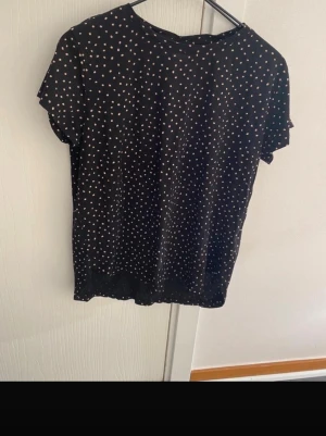 Söt Prickig topp strl 34   - Strl s fint skick. Svart  med prickar mkt fint skick och snyggt fall 