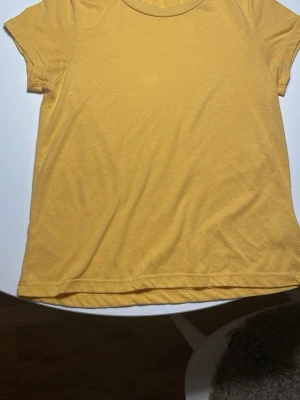 Gul kortärmad t-shirt i bomull - Snygg gul t-shirt med korta ärmar och rund hals. Tillverkad i mjuk bomull som känns skön mot huden. Enkel och clean design utan mönster eller detaljer, perfekt för dig som gillar basic och färg.