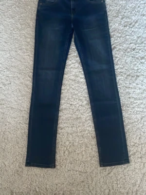 Cheap Monday Tight jeans blå W29 L32 - Säljer ett par Cheap Monday Tight jeans i mörkblå tvätt med slim fit och smala ben. Modellen har medium midja och är tillverkad i ekologisk bomull. Klassisk femficksdesign och läderpatch med logga bak. Perfekt för dig som gillar en clean och modern look.