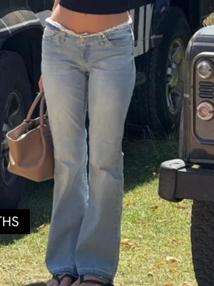 Bootcut jeans med rå kant från Nelly - Bootcut jeans i ljusblå tvätt från Nelly med låg midja och rå, fransad kant upptill. Jeansen har klassisk femficksdesign, breda ben och slitna detaljer vid benslutet. Materialet är mjuk denim i bomull med en loose passform. Nypris 699