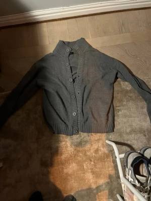 Grå stickad cardigan - En grå stickad cardigan/ kofta från park. Är i storlek L men den sitter bra på storlek M också, personen på bilden är i storlek M.
