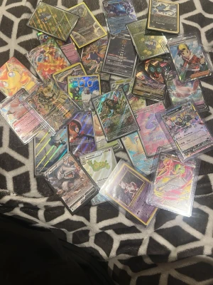 28 Pokémon kort alla riktiga  - Bilderna visar en samling Pokémonkort i olika färger och motiv, men ingen väst finns med på någon av bilderna.