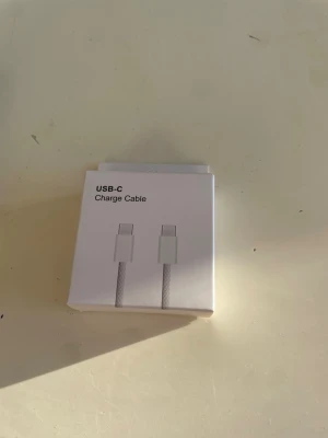 USB-C Charge Cable - Ny USB-C laddningskabel i originalförpackning. Perfekt för laddning och dataöverföring till kompatibla enheter. Förpackningen är obruten och kabeln är oanvänd. Passar till många moderna smartphones, surfplattor och laptops med USB-C port.