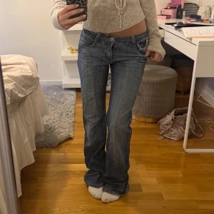 Blå bootcut jeans  - Säljer ett par lågmidjade/ midwaist jeans som jag köpte på Vinted men som tyvärr är lite stora på mig. Mått rakt över: 36cm, innerben: 82 cm💗knappen sitter lite löst men går säkert att fixa enkelt