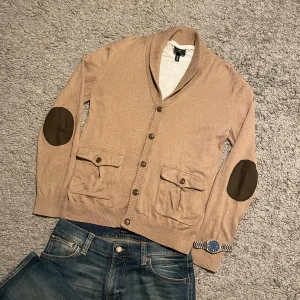 Beige cardigan  - Säljer en stilren trendig cardigan! 🙌🏻Tröjan har 5 klassiska knappar upp till, med en stil riktad mot ”oldmoney”. Tveka inte på att höra av er!💪