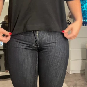 Mörkblå bootcut jeans med kontrastsöm - Snygga mörkblå jeans med bootcut passform och coola kontrastsömmar. Bakfickorna har ett gult zigzag-broderi som sticker ut. Jeansen har klassisk dragkedja och är tillverkade i stretchigt denim för en bekväm känsla. Dom är uppsydda va 5 cm. Och är precis över hälen på mig som är 163