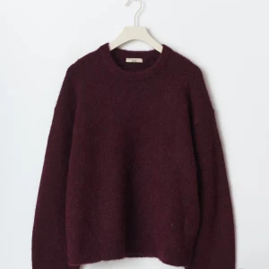 Vinröd stickad tröja med rund hals - Mysig vinröd stickad tröja från Gina tricot med rund halsringning och långa ärmar. Tröjan har en lite loose passform och är perfekt för kyliga dagar. Materialet är mjukt och fluffigt, vilket gör den extra skön att bära.