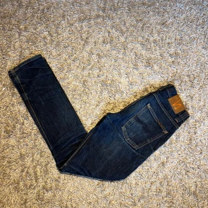 Nudie Jeans Grim Tim org navy W29 L32 - Mörkblå jeans från Nudie Jeans, modell Grim Tim, i org navy tvätt. Klassisk femficksdesign, raka ben och orangea sömmar. Tillverkade i 98%  bomull och 2% elastan för lite stretch. Postas antigen samma dag som köp eller dagen därpå🙌💯