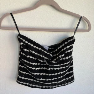 Randig svartvit linnetopp från Amisu - Säljer en svart och vit randig linnetopp från Amisu i storlek M. Toppen har tunna axelband och är tillverkad i ett mjukt, stickat material. Perfekt för dig som gillar en cool och trendig look med lite retrovibbar.