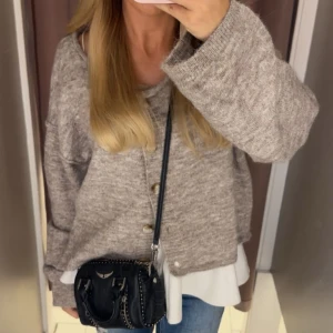 Beige brun  kofta med knappar - Mysig beige kofta med knappar framtill och långärmad design. Koftan har en loose passform och är tillverkad i ett stickat material som passar perfekt för kyligare dagar. Enkel att matcha med jeans eller kjol för en avslappnad look. Är i använt skick lite nopprig(inte alls mycket se bild två) fråga gärna om fler bilder så fixar jag det 