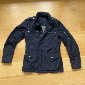 Field jacka - Snygg mörkblå field jacka från Riley, perfekt jacka till hösten när det börjar bli lite kallare. Den är i nyskick och endast använd ett par gånger. Skulle säga att den är i storlek S-M men närmare S. Nypris 2199, vid funderingar skriv dm. 