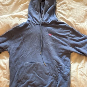 Blå hoodie från Levi's - Säljer en blå hoodie från Levi's. Liten röd Levi's-logga på bröstet. Skön passform och perfekt för chill dagar. Materialet är mjukt och känns som bomull. Långärmad modell.❤️🥰