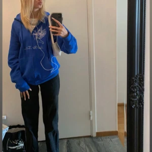 Blå hoodie med strasstenar och ängel - Blå hoodie köpt från ett märke på instargram som jag tyvärr inte minns vad det hette. Dragkedja, huva och fickor. På bröstet finns ett motiv av en ängel i strasstenar och text. Perfekt för dig som gillar streetstyle och vill sticka ut lite extra. Första bilden är när jag precis köpte tröjan och andra är hur den ser ut idag, några stenar har lossnat och snöret som en gång suttit i luvan finns inte kvar längre. Annars är den i gott skick!☺️