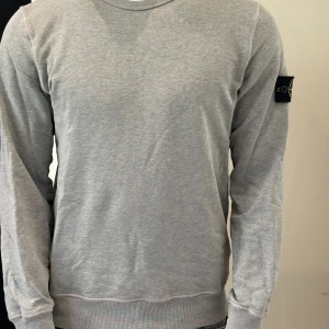 Grå sweatshirt från Stone Island - Säljer en stilren grå sweatshirt från Stone Island med klassisk patch på vänster ärm. Nypris 2899kr! Vårt pris endast 799! Storlek L junior!