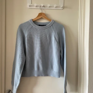 Ljusblå stickad tröja från French Connection - Snygg ljusblå stickad tröja från French Connection i storlek L. Tröjan har rund hals, ribbade muddar och en liten slits i sidan. Perfekt för dig som gillar enkel och stilren design med en chill vibe.