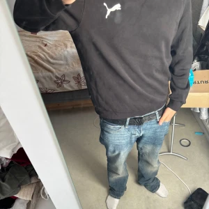 Svart sweatshirt från Puma, storlek L - Svart sweatshirt från Puma i storlek L. Klassisk crewneck med vit Puma-logga på bröstet. Tröjan har ribbade muddar vid ärmslut och nederkant. Perfekt basic till garderoben och funkar året runt. Pris går att diskutera 