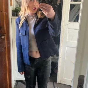 Mörkblå kappa - Säljer en mörkblå kappa med två stora fickor framtill och knappar. Jackan har en rak passform och är långärmad men fortfarande tunn, perfekt för en stilig outfit! (Intressekoll)