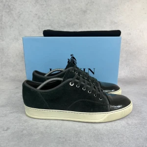 LANVIN DBB1 CAP TOE SNEAKER - – Condition: 9/10  - Size: 44/UK10  – What is included: Dustbag  – Retail price: 5000 + SEK  Please note that Lanvins fit big and our recommendation is to go one size down