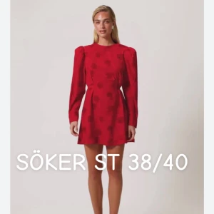 Röd blommig kortklänning med puffärm - Superfin röd kortklänning med diskret blommigt mönster och puffiga långärmar. Klänningen har rund hals och markerad midja som ger en snygg siluett. Perfekt för dig som vill sticka ut med färg och coola detaljer.