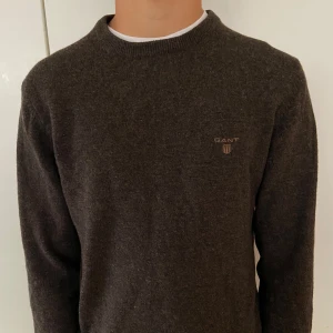 Brun stickad tröja från GANT - Mysig brun stickad tröja från GANT med broderad logga på bröstet. 