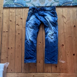 Blå Diesel straight jeans - Säljer ett par blekta blå jeans från Diesel med snygga slitningar och och straight passform. W 32 L 30. Skriv vid frågor!