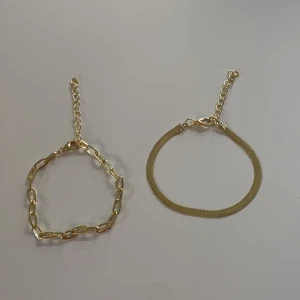 Två guldiga armband i olika stilar - Säljer två snygga armband i guldton då de är förstora. Armbandet på vänster sida är 15 cm med 5 cm tillägg. Armbandet till höger är 16 cm med 5 cm tillägg. 